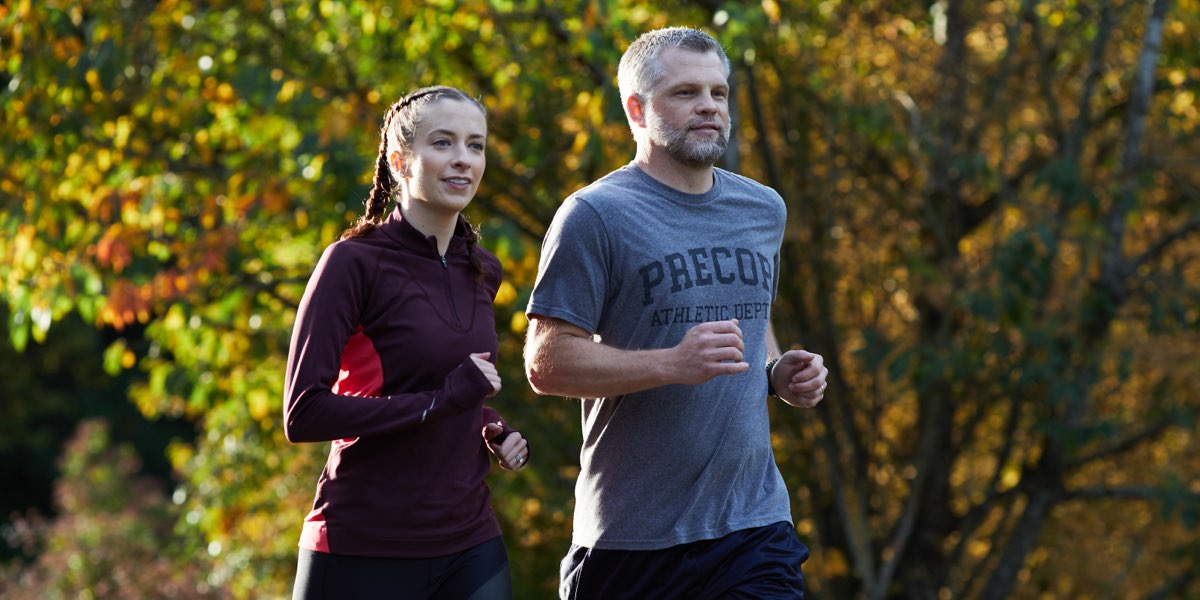 Man and woman running outside during the fall