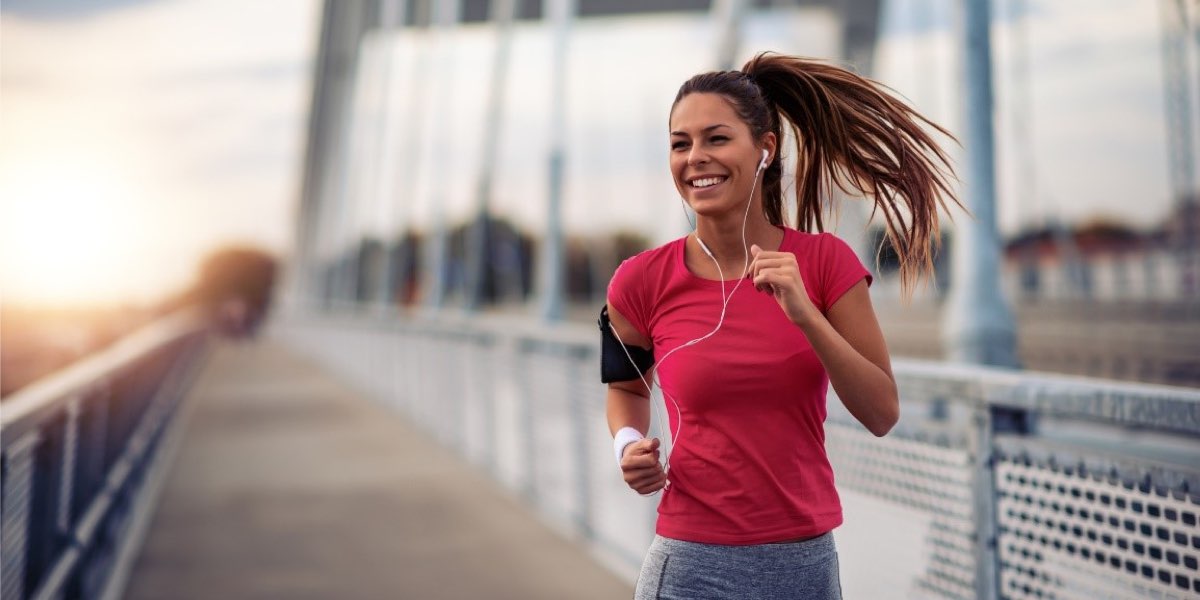 Happy female running outside over a bridge