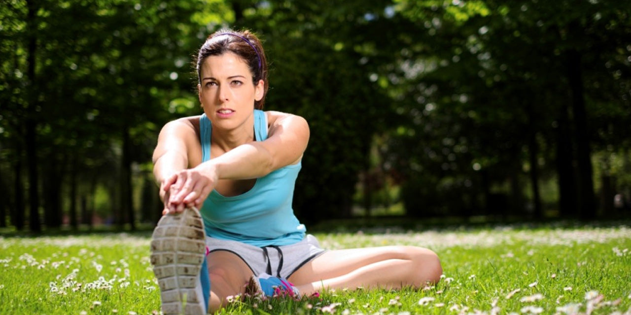 Female outside in the grass stretching