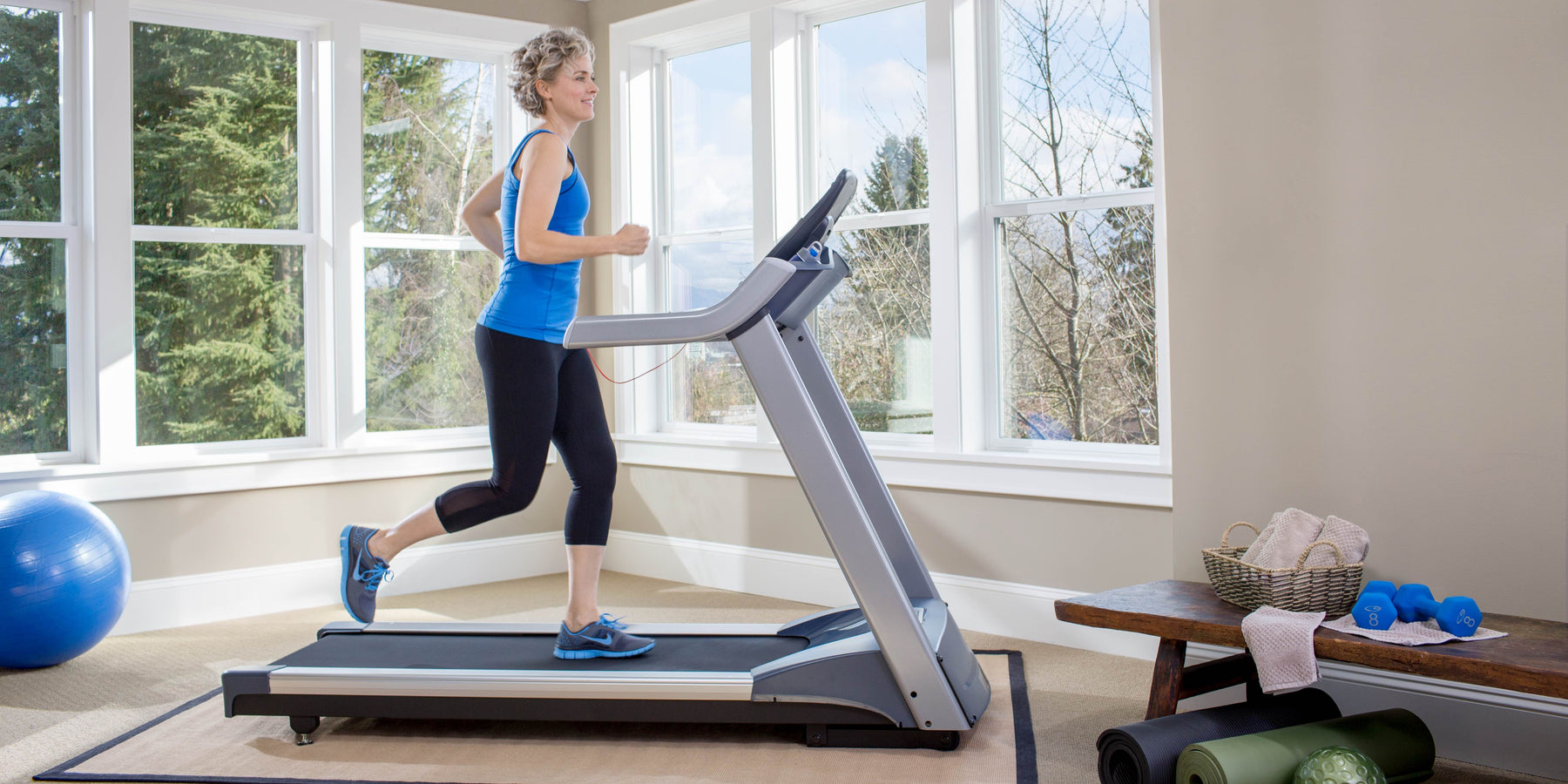 female exerciser cardio workout on Precor TRM 400 line treadmill at home