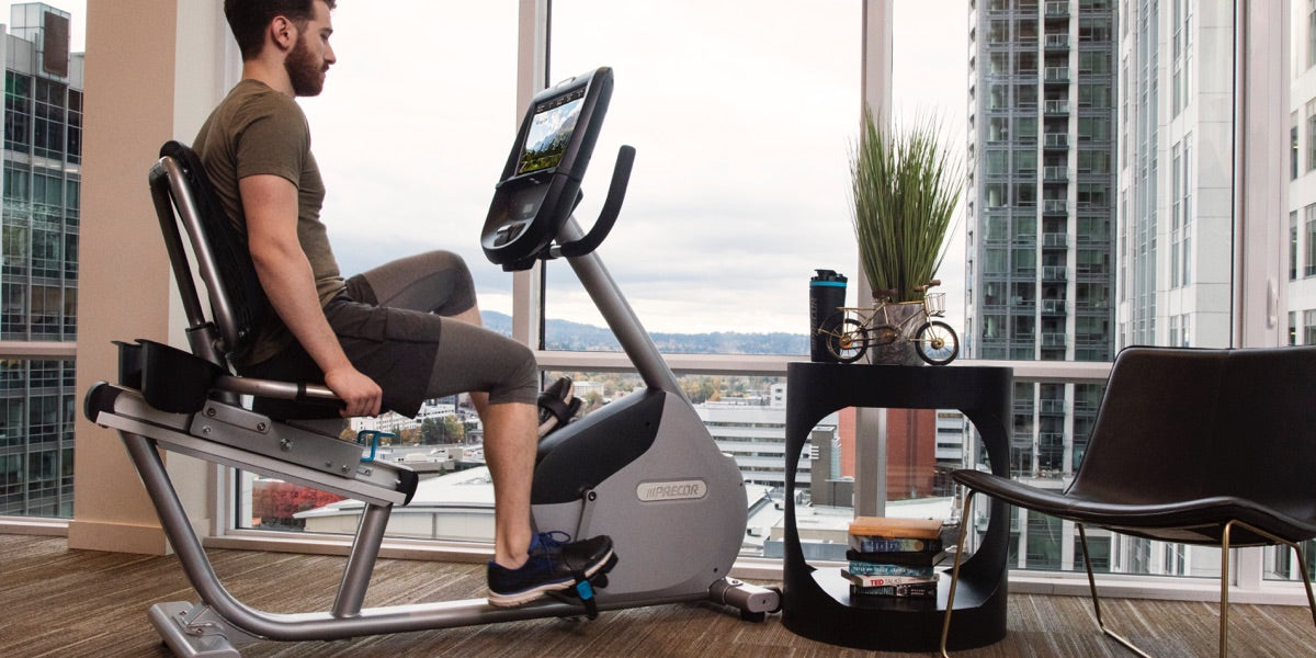 Man exercising on a Precor RBK 865 recumbent bike in his home gym