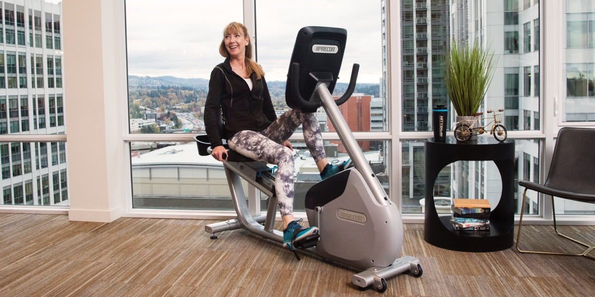 Woman working out in her home on a Precor recumbent bike RBK 885