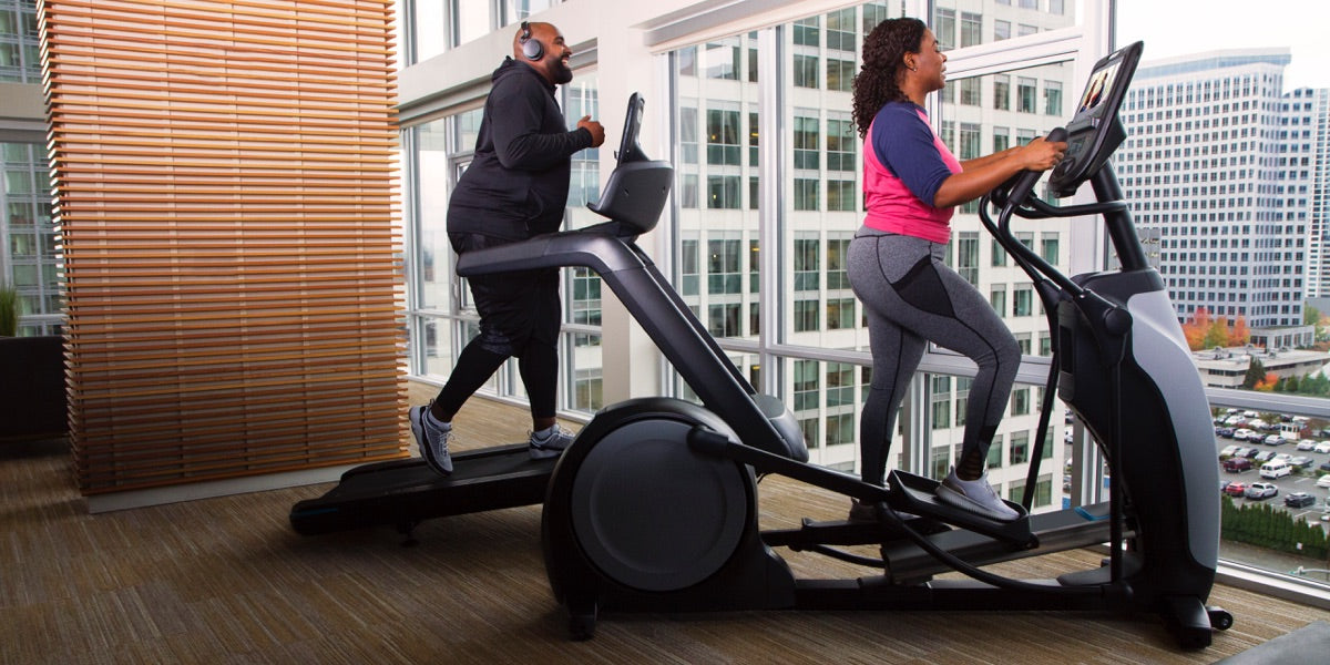 Male and female working out in their home gym on a Precor elliptical EFX 685 and a Precor treadmill TRM 681