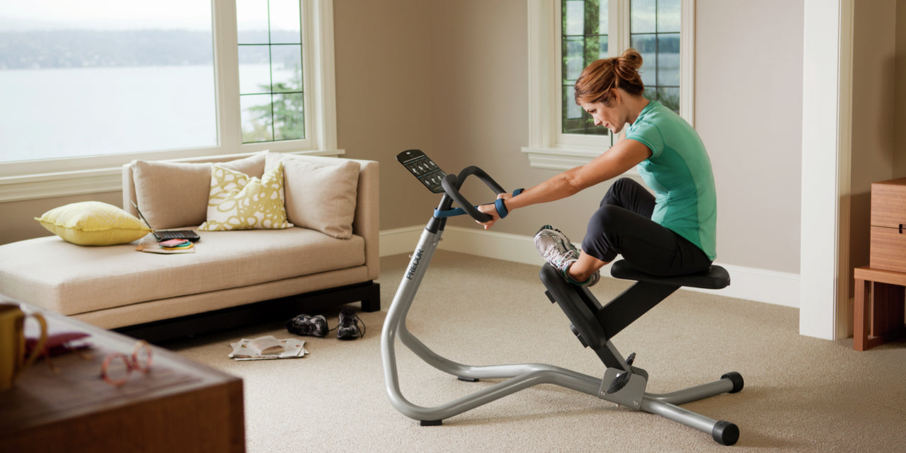 Female in her living room using the Precor 240i StretchTrainer