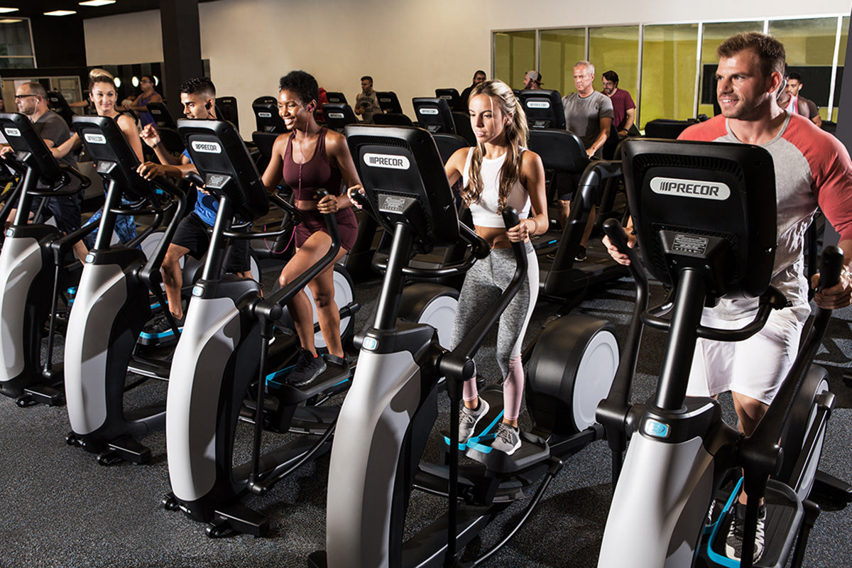 Precor professional elliptical fitness crosstrainer in a fitness center with exercisers working out