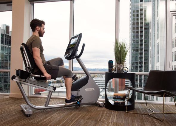 Man working out at home on a Precor RBK 885 recumbent stationary bike