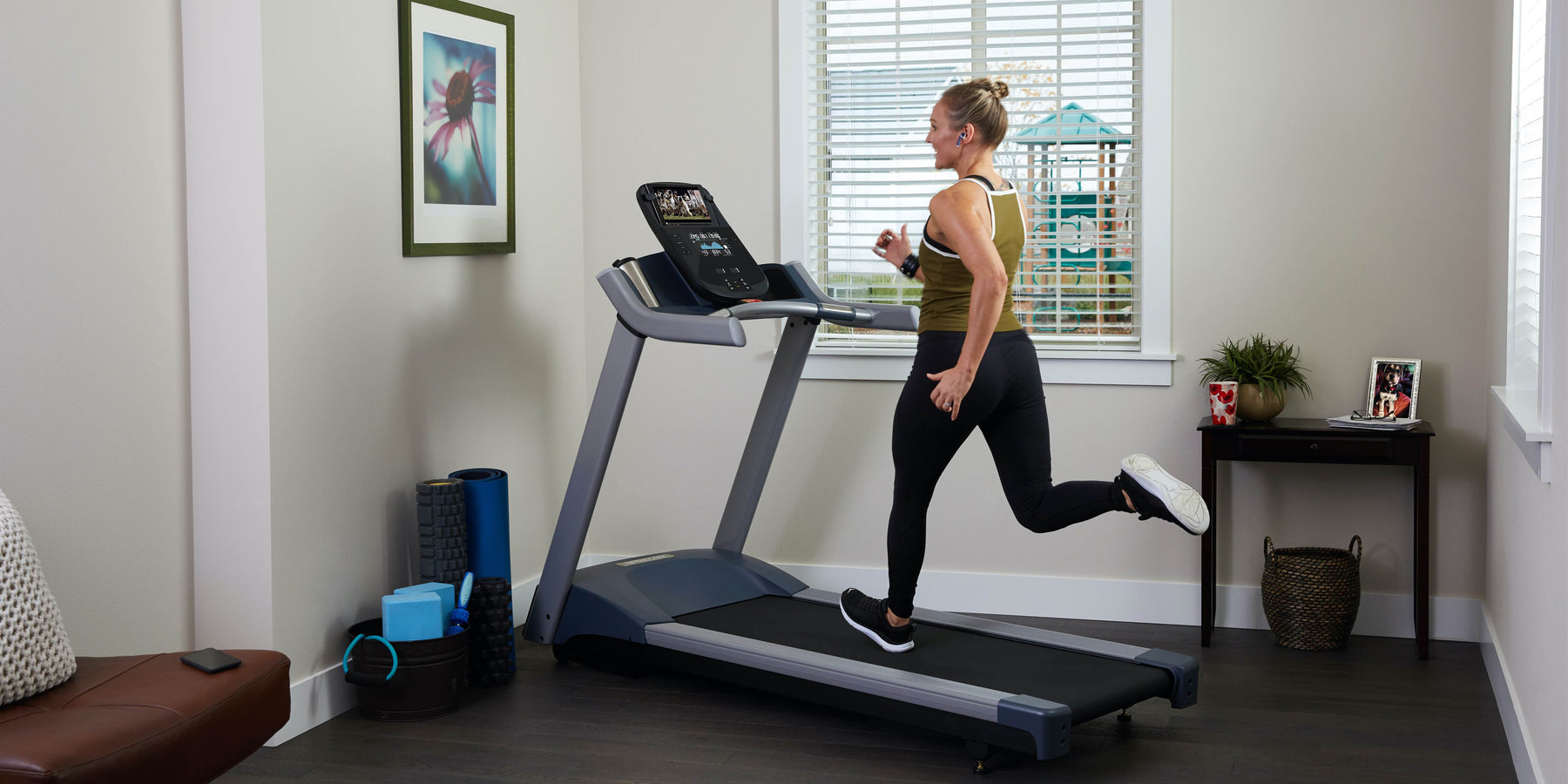 female exerciser cardio workout on Precor TRM 200 line treadmill at home